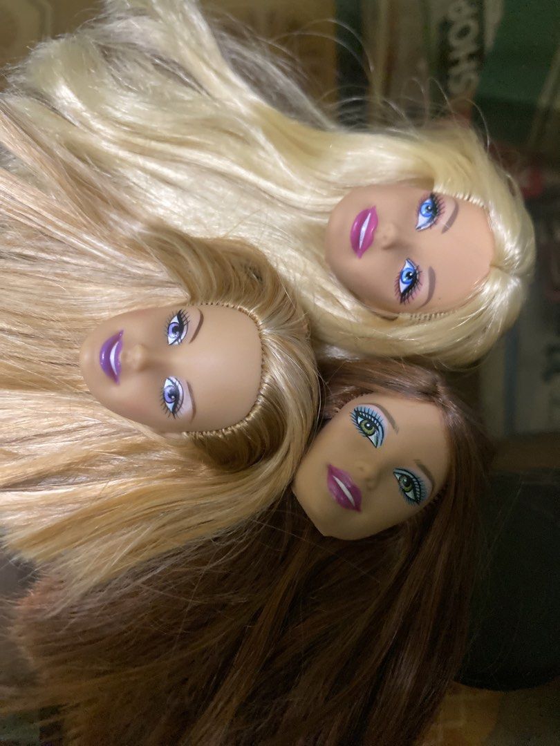 Barbie Doll Heads Bundle (Category: Toys & Games) located in Manila. Submitted by dion2004 (Listing ID 1436224323, Image 3). Description: Three Barbie doll heads with different hair colors: blonde, light brown, and dark brown. Each head features detailed facial features, including eye makeup and lip color. The blonde head has blue eyes, the light brown head has purple eyes, and the dark brown head has green eyes. These doll heads are perfect for 