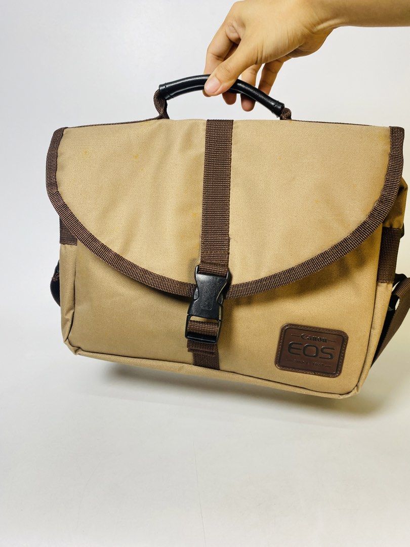 Canon EOS Camera Bag Brown (Category: Camera Bags & Carriers) located in Bacoor. Submitted by banananana12 (Listing ID 1436143341, Image 1). Description: Canon EOS Brown Bag 11.5 x 9.5 x 4 inches - Tan Canon EOS camera bag with brown accents - Includes a shoulder strap and top handle - Features a front flap closure - Canon EOS logo patch - Main compartment - Zippered pocket - Mesh pocket inside Bacoor,Cavite Flash Express / Lalamove.