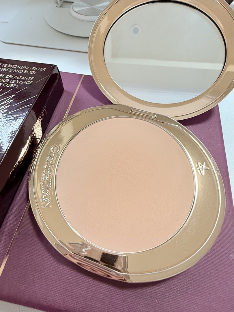 Charlotte Tilbury Airbrush Bronzer (Category: Makeup) located in Butuan. Submitted by graceeeee88 (Listing ID 1436274807, Image 3). Description: BIGGEST SIZE! - Charlotte Tilbury Airbrush Bronzer - Matte bronzing filter for face and body - Golden shade - Refillable and rechargeable - Comes in original packaging - Features a geometric box design with the brand's logo.