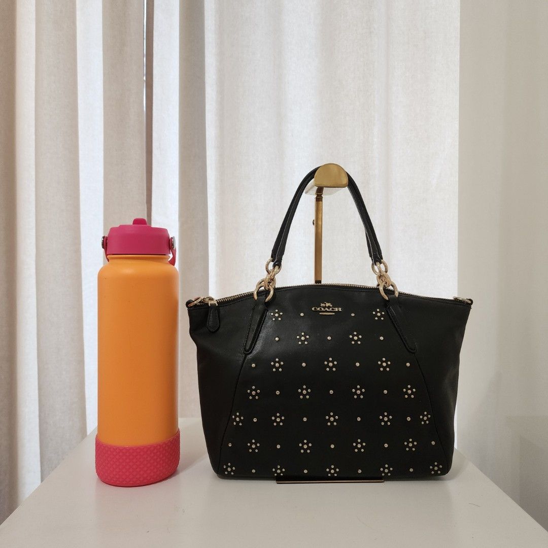 Coach Kelsey Black Studded Tote Bag (Category: Luxury Bags & Wallets) located in Quezon City. Submitted by urbangypsy (Listing ID 1436174675, Image 3). Description: - Authentic Coach tote bag - Black leather exterior - Gold-tone hardware - Studded details - Dual top handles - Secure zip closure - Classic design.