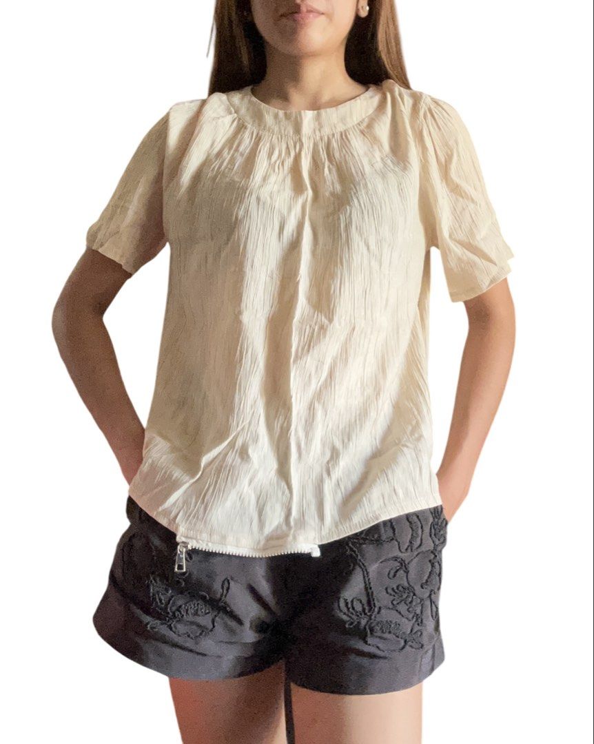 Cream-colored Short-Sleeved Top (Office) (Category: Blouses) located in Silang. Submitted by seachels30 (Listing ID 1436169140, Image 2). Description: - Cream-colored top - Short sleeves - Round neckline - Textured fabric - Relaxed fit - Small opening at the back - Versatile for casual outfits.