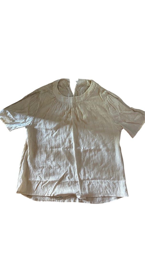 Cream-colored Short-Sleeved Top (Office) (Category: Blouses) located in Silang. Submitted by seachels30 (Listing ID 1436169140, Image 1). Description: - Cream-colored top - Short sleeves - Round neckline - Textured fabric - Relaxed fit - Small opening at the back - Versatile for casual outfits.