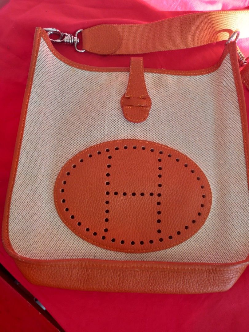 Hermes Canvas Shoulder Bag (Category: Luxury Bags & Wallets) located in Tuguegarao City. Submitted by zenphoenix-7ad615 (Listing ID 1436285959, Image 1). Description: - Orange and cream canvas shoulder bag - Orange leather trim and shoulder strap - Features an oval leather patch with the Hermes logo - Silver-tone hardware - Flap closure with leather tab 11.20 by 10.5 inches.