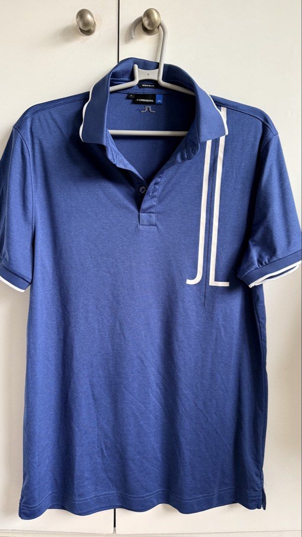 j.lindeberg Blue Polo Shirt (Category: Tshirts & Polo Shirts ) located in Valenzuela. Submitted by dees.corner (Listing ID 1436165722, Image 1). Description: Blue J.Lindeberg polo shirt with white accents. Features the J.Lindeberg logo on the chest and buttons. Made of 100% polyester. Regular fit. Made in Taiwan. Size M. W 17, L 30.