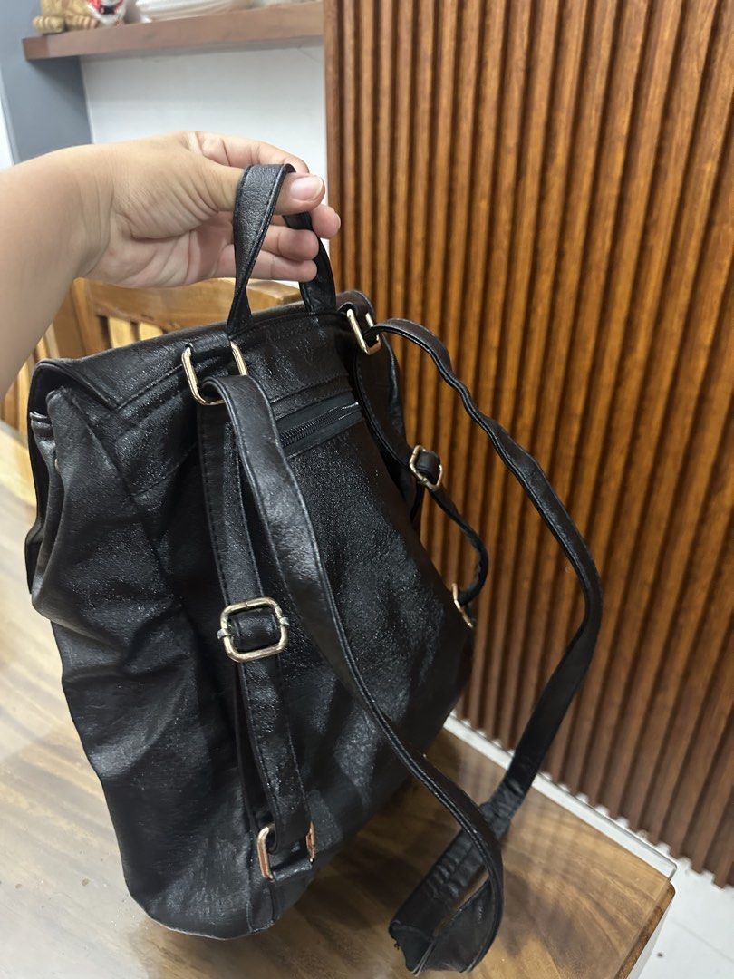 Kate Spade New York Black Backpack Convertible (Category: Backpacks) located in Batangas. Submitted by jhinp0t (Listing ID 1436231316, Image 3). Description: Genuine Leather Black Kate Spade backpack with two front pockets. Features a top handle and adjustable shoulder straps. The interior has a Kate Spade label and a zipper pocket. The zipper pull has the Kate Spade logo. The backpack has gold-tone hardware. Issue: This is my project bag brought