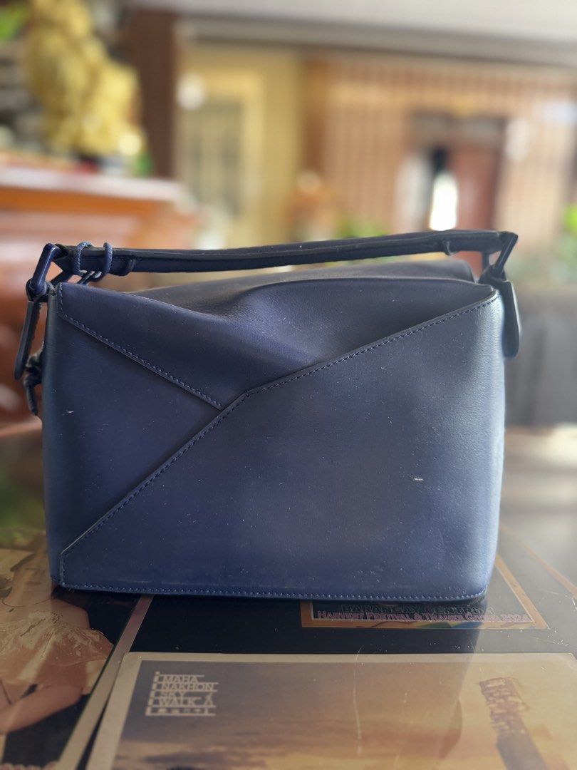Pre owned L Puzzle Bag Navy Blue (Category: Luxury Bags & Wallets) located in Luna. Submitted by carolina_closetph (Listing ID 1436114970, Image 1). Description: - Authentic Loewe Puzzle bag in navy blue. - Features a top handle and a detachable shoulder strap with the Loewe logo. - Secure zipper closure. - Made from high-quality leather. - Distinctive geometric design..