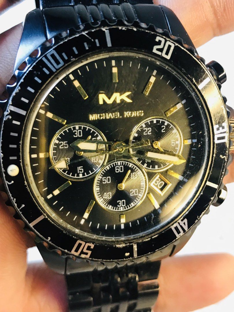 Michael Kors Black Chronograph Watch (Category: Luxury Watches) located in Manila. Submitted by zerimar01 (Listing ID 1436231516, Image 2). Description: - Michael Kors watch - Black dial with gold accents - Chronograph subdials - Black stainless steel bracelet - Rotating bezel - Michael Kors logo on dial and clasp - In good working condition.