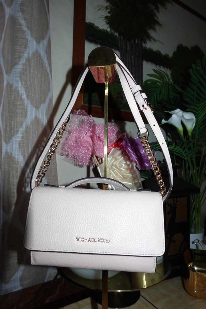 Michael Kors Pink Crossbody Bag (Category: Luxury Bags & Wallets) located in Manila. Submitted by ashfinds.mnl (Listing ID 1436279235, Image 1). Description: - Authentic Michael Kors crossbody bag - Light pink color - Elegant gold chain strap - Secure flap closure with Michael Kors logo - Interior with card slots and multiple compartments - Convenient top handle - Crafted from genuine leather.