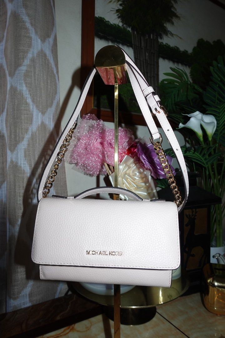 Michael Kors Pink Crossbody Bag (Category: Luxury Bags & Wallets) located in Manila. Submitted by ashfinds.mnl (Listing ID 1436279235, Image 2). Description: - Authentic Michael Kors crossbody bag - Light pink color - Elegant gold chain strap - Secure flap closure with Michael Kors logo - Interior with card slots and multiple compartments - Convenient top handle - Crafted from genuine leather.