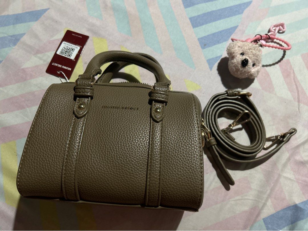 Mumu Select Cylinder Handbag with Strap (Category: Shoulder Bags) located in Manila. Submitted by emsmerize (Listing ID 1436197193, Image 1). Description: - Mumu Select cylinder handbag - Detachable shoulder strap and top handle - Textured exterior with buckle details - Includes a small dog keychain - Perfect for everyday or special occasions - Comes with original tag.