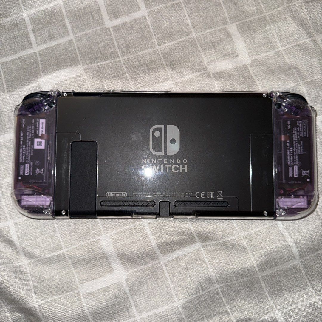 Nintendo Switch V1 Bundle (Category: Nintendo) located in Bacoor. Submitted by the_meowchant (Listing ID 1436161309, Image 3). Description: Nintendo Switch V1 Bundle - Lightly used, still smooth, screen protected since Day 1 - Unit only with premium accessories, no games - Joy-cons modded with custom atomic purple transparent shell - Comes with original box and inclusions (dock, charger, joy-con adapter/straps - With free Skull & Co Carry Case, 8