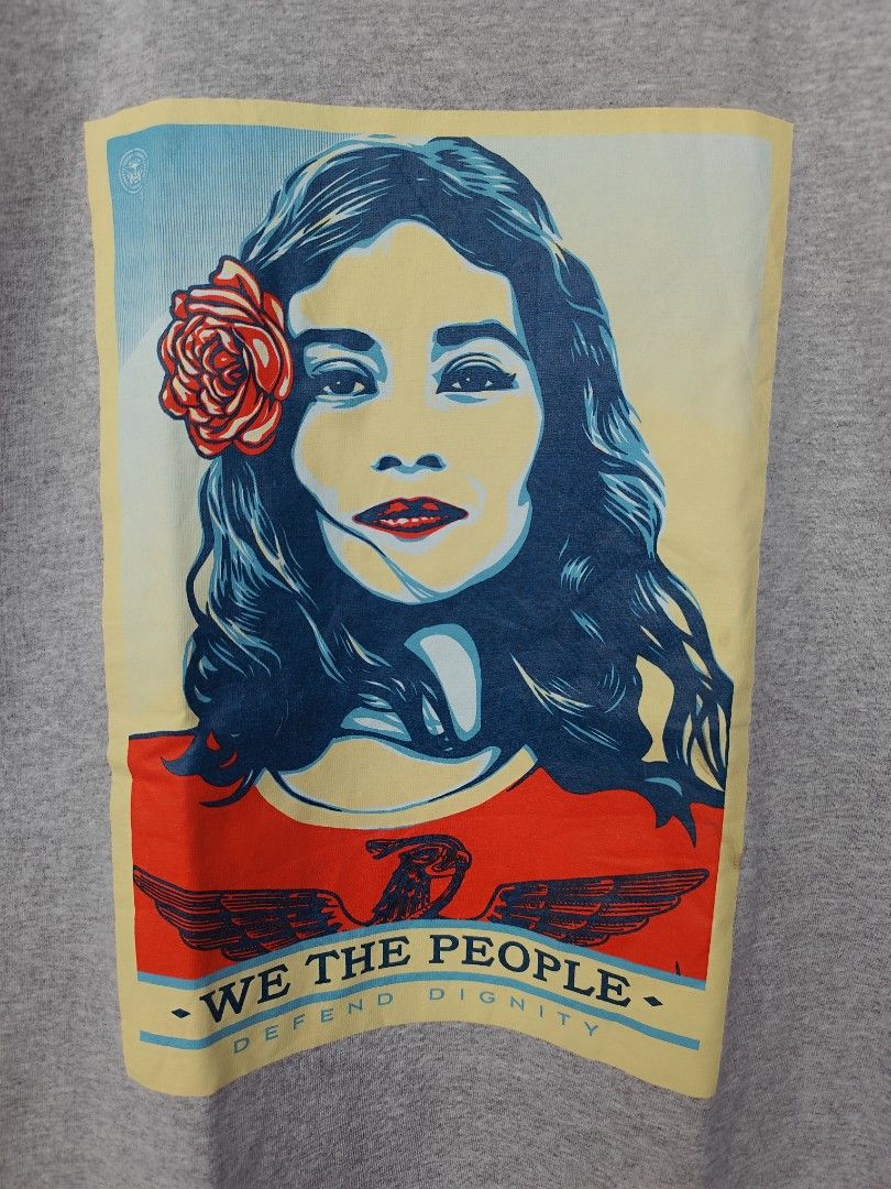 Obey We The People Graphic Tee (Category: Tshirts & Polo Shirts ) located in Pasig City. Submitted by keilahsmom (Listing ID 1436236363, Image 2). Description: Dimes: L26 W17 1/2 Size on tag: S Color rate: 10/10 Condition: Excellent 10/10 Issue(s): none Buong buo ang print walang crack or any hair line. Grey Obey t-shirt features a graphic print on the front with the words "We The People" and a portrait of a woman with a rose. The back of the shi