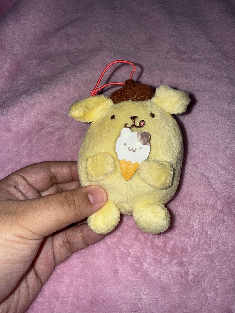 Pompompurin Plushie Keychain (Category: Toys & Games) located in Bulacan. Submitted by xxmeiji (Listing ID 1436102466, Image 1). Description: - Adorable Pompompurin plushie keychain - Features Pompompurin holding an ice cream cone - Comes with a brown hat and red string - Yellow plushie with a cute expression - Great for Sanrio fans and cute accessory lovers!.