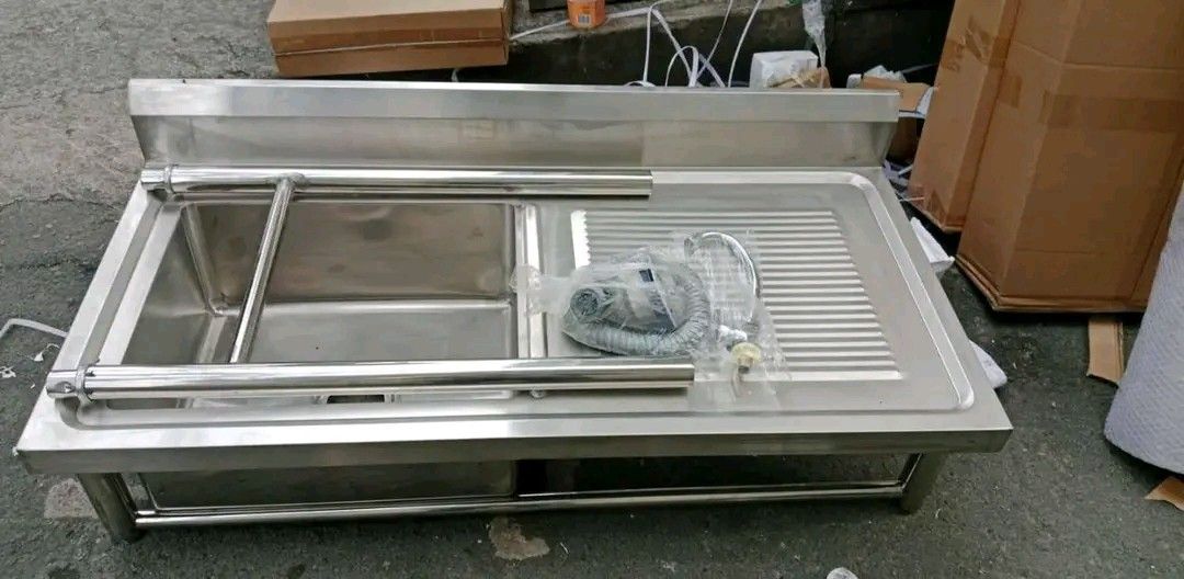 Stainless Steel Commercial Sink (Category: Bathroom & Kitchen Fixtures) located in Quezon City. Submitted by maryjoycan74524 (Listing ID 1436217352, Image 2). Description: - Commercial stainless steel sink - Single basin design - Includes drainboard - Features a lower shelf for storage - Comes with a faucet - Made of durable stainless steel - Perfect for restaurants and food businesses - Heavy-duty construction - Multiple units available.