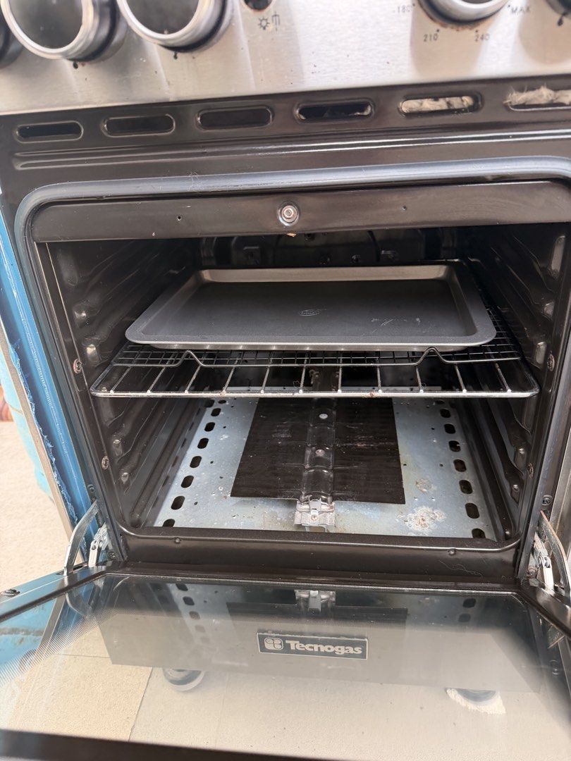Tecnogas 4-Burner Gas Range with Oven (Category: Ovens & Toasters) located in Quezon City. Submitted by r.tp07 (Listing ID 1436218720, Image 2). Description: - Tecnogas gas range - 3 burners - Oven - Multiple rack levels in oven - Stainless steel finish - Glass cover for burners - Visible control knobs.