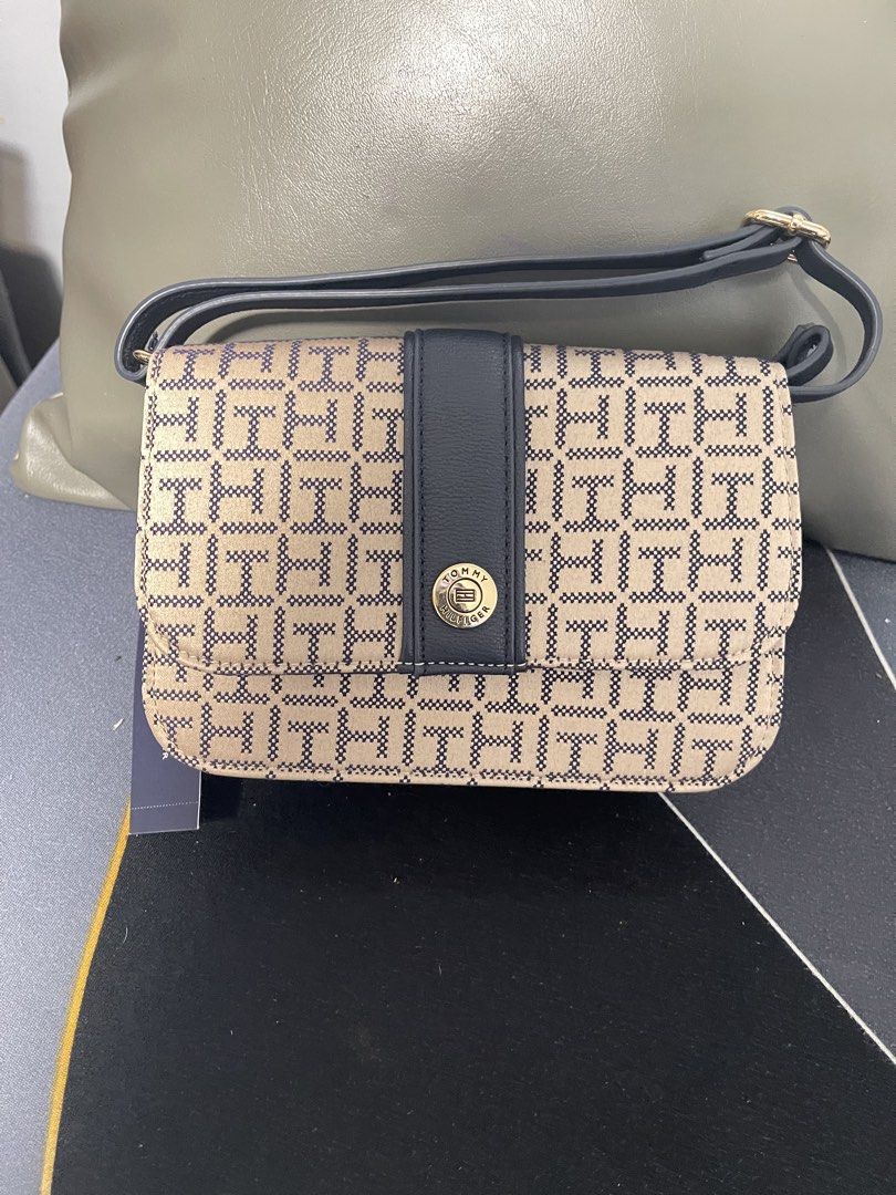Tommy Hilfiger Crossbody Bag (Category: Cross-body Bags) located in Binangonan. Submitted by chasechloe (Listing ID 1436235669, Image 1). Description: - Tommy Hilfiger crossbody bag - Color: Beige and navy - Signature logo pattern - Flap closure with gold-tone button - Navy strap (shoulder/crossbody) - Compact design - Ideal for everyday wear MOD : LBC (COP/COD with downpayment) J&T (payment first, no COP/COD) Pick up sa malapit MOP : bank transf