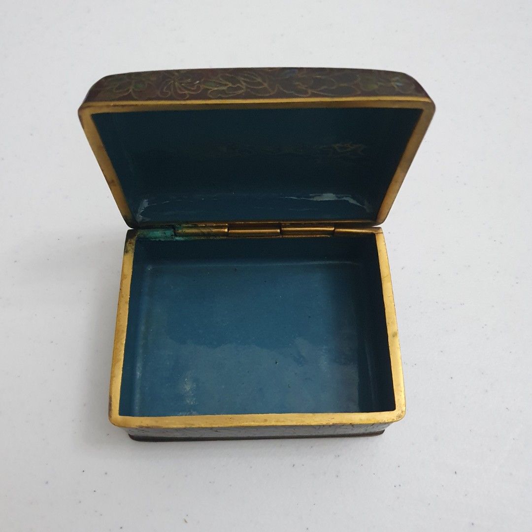 Vintage Floral Enamel Box (Category: Accessory Holder, Box & Organizers) located in Paranaque City. Submitted by cobien (Listing ID 1436284955, Image 3). Description: - Vintage floral enamel box - Rectangular shape - Hinged lid with gold-colored trim - Teal interior - Made of metal - Dimensions: Approx. 3.75 x 2.75 x 2 inches.