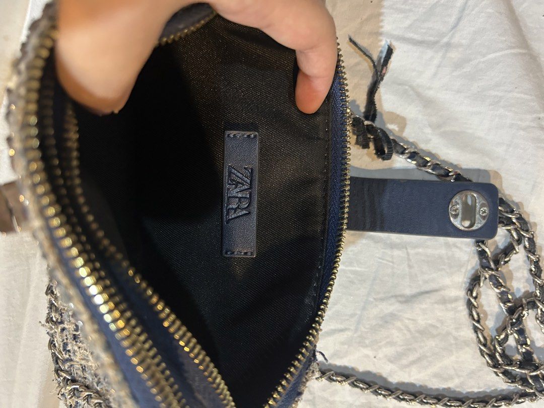 Zara Tweed Chain Bag (Category: Shoulder Bags) located in Marikina City. Submitted by decluttering522 (Listing ID 1436224730, Image 2). Description: Zara bag features a tweed exterior with a chain strap. It has a navy blue interior with a zipper closure. The bag has a flap with a snap closure. The interior has a Zara label. The chain strap is silver-toned..
