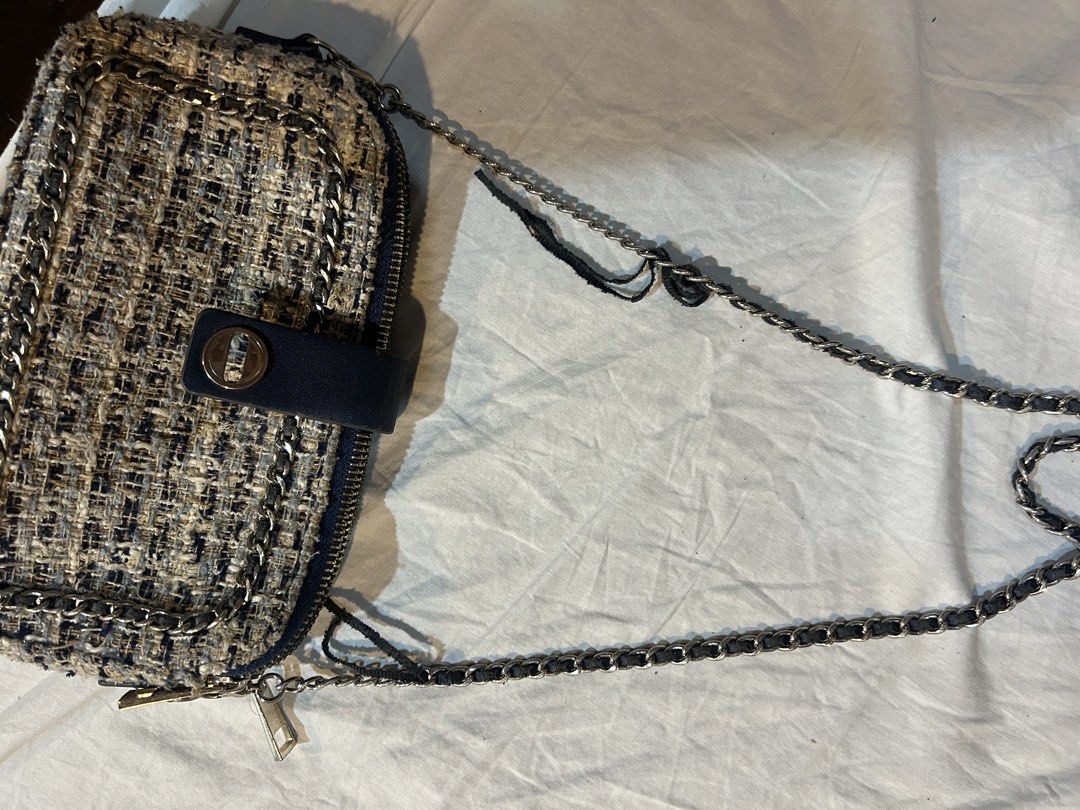 Zara Tweed Chain Bag (Category: Shoulder Bags) located in Marikina City. Submitted by decluttering522 (Listing ID 1436224730, Image 3). Description: Zara bag features a tweed exterior with a chain strap. It has a navy blue interior with a zipper closure. The bag has a flap with a snap closure. The interior has a Zara label. The chain strap is silver-toned..