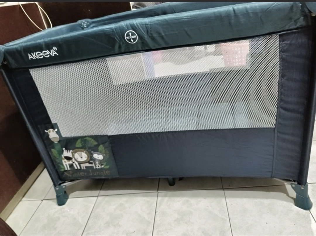 Akeeva Multifunctional Crib and playpen (Category: Cots & Cribs) located in Quezon City. Submitted by karlisleshop (Listing ID 1436298520, Image 1). Description: - Akeeva playard with Winter Jungle theme - Dark blue color - Mesh sides for visibility - Includes a canopy - Padded base for comfort - Features a storage pocket - Designed for babies and young children.
