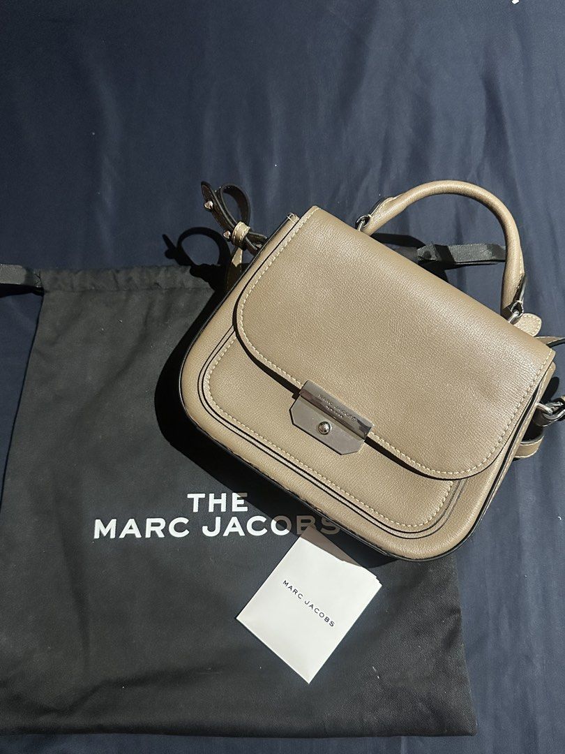 Authentic The Marc Jacobs Saddle Bag (Category: Luxury Bags & Wallets) located in Quezon City. Submitted by rempgo (Listing ID 1436452033, Image 1). Description: - Authentic The Marc Jacobs Saddle Bag - Slightly used - Neutral taupe exterior - Classic saddle bag design - Flap closure with silver-tone metal clasp - Includes dust bag and tag - Interior zippered pocket - Versatile top handle and shoulder strap - with minimal damage due to long stora