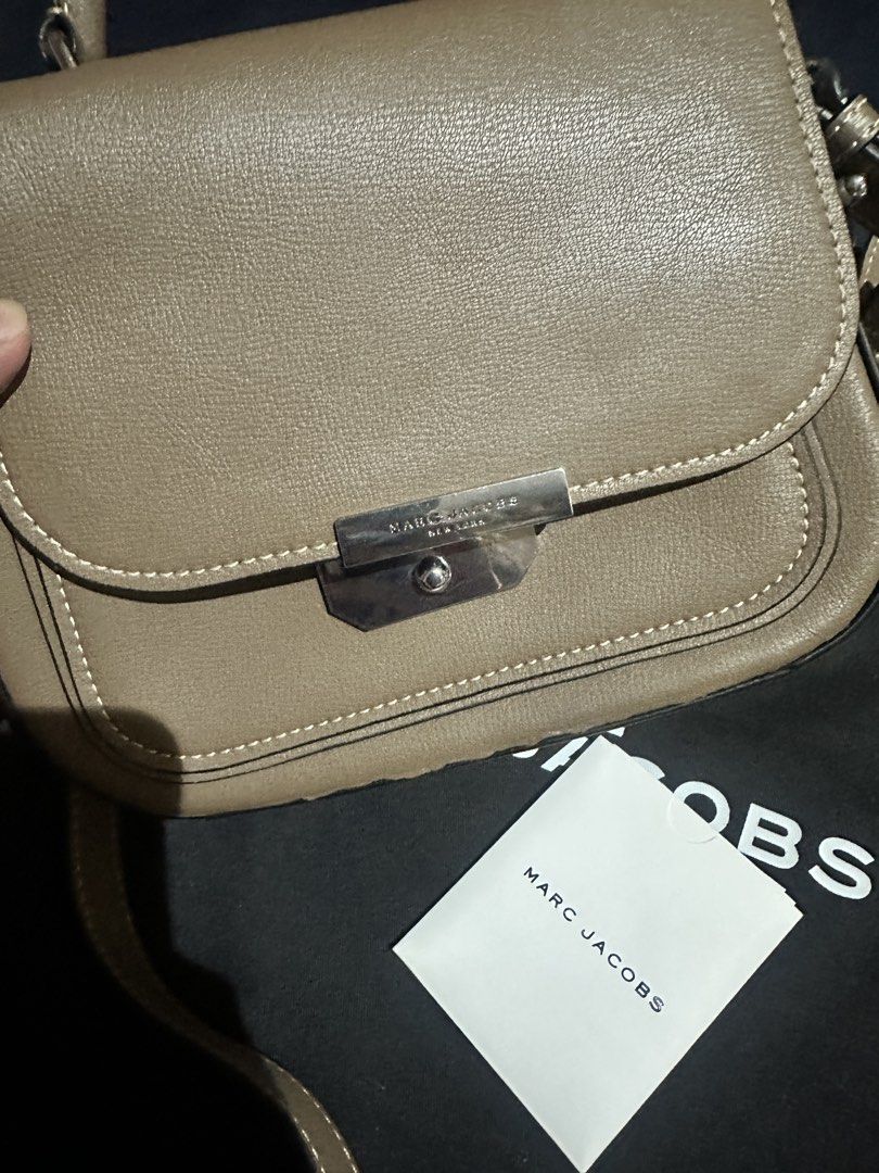 Authentic The Marc Jacobs Saddle Bag (Category: Luxury Bags & Wallets) located in Quezon City. Submitted by rempgo (Listing ID 1436452033, Image 2). Description: - Authentic The Marc Jacobs Saddle Bag - Slightly used - Neutral taupe exterior - Classic saddle bag design - Flap closure with silver-tone metal clasp - Includes dust bag and tag - Interior zippered pocket - Versatile top handle and shoulder strap - with minimal damage due to long stora