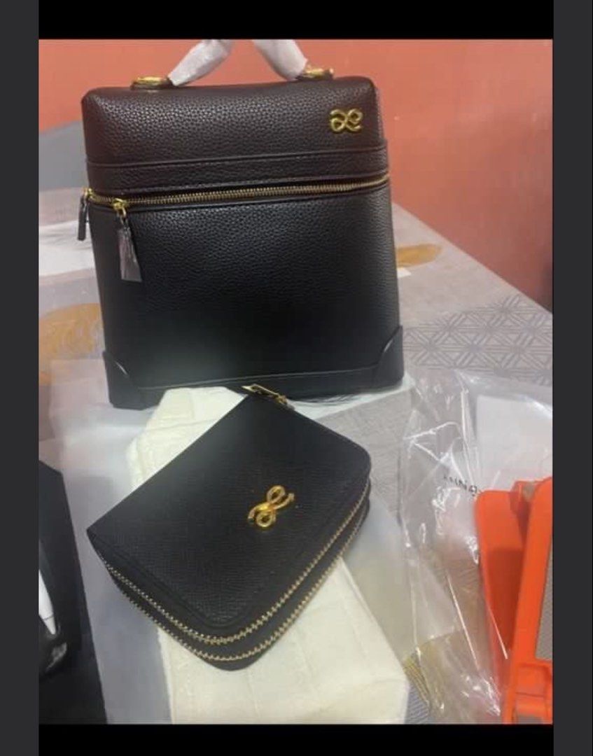 Black Handbag Set with Gold Accents (Category: Luxury Bags & Wallets) located in Manila. Submitted by devorahlop39116 (Listing ID 1436299012, Image 1). Description: Set includes a black handbag and a matching wallet, both featuring gold-colored zippers and a decorative gold bow emblem. The handbag has a structured design with a top handle and a zippered compartment. The wallet is compact with a double zipper closure. Both items appear to be made 