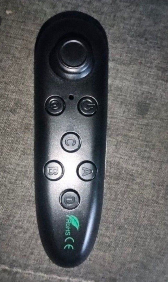Bluetooth Remote Controller (Category: Controllers) located in Kuala Langat. Submitted by aqasha1713 (Listing ID 1436420755, Image 3). Description: Bluetooth remote controller. It has multiple buttons, including a joystick and buttons labeled A, B, C, and D. The controller is black and comes in a white box. The box indicates it is a Bluetooth remote controller..