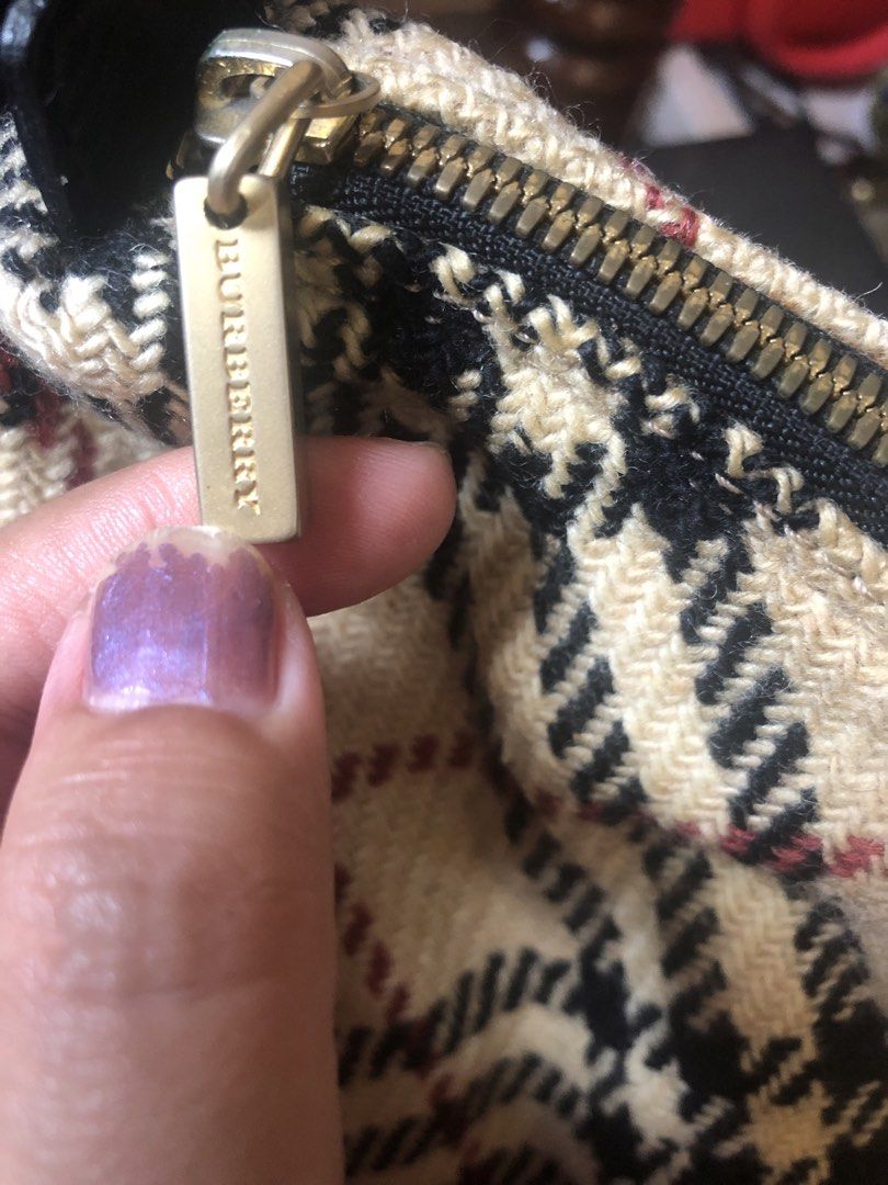 Burberry Checkered Shoulder Bag (Category: Luxury Bags & Wallets) located in Tabuk. Submitted by qurst (Listing ID 1436312941, Image 2). Description: - Authentic Burberry shoulder bag - Classic checkered pattern - Black strap - Gold-toned zipper with Burberry logo - Red interior lining - Made in Italy.