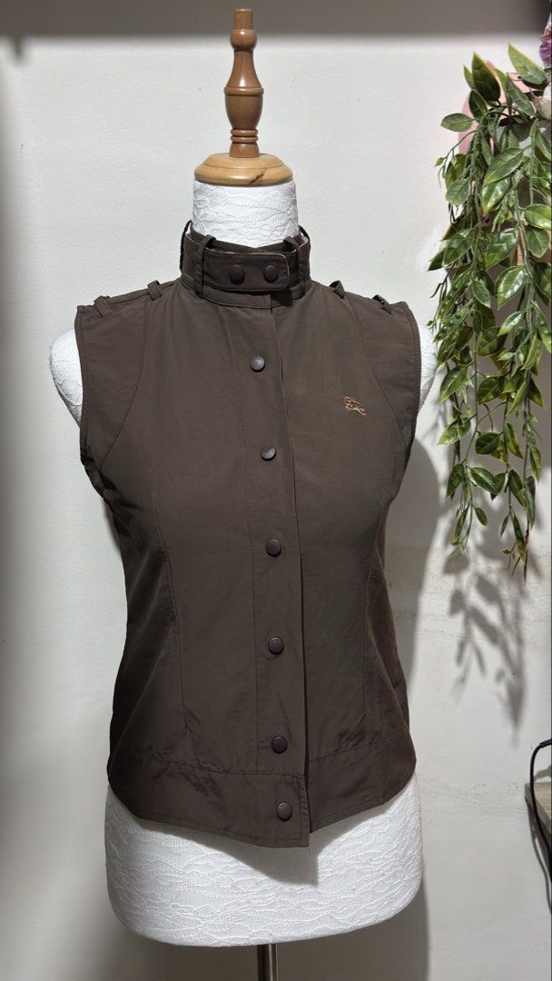 Burberry London Vest (Category: Others Tops) located in Cebu City. Submitted by cherrythrift_picks (Listing ID 1436388527, Image 1). Description: - Burberry London vest - Rich brown color - Small size - Collared design with button closures - Features Burberry logo - Check pattern on collar - 100% cotton lining - Perfect for layering.