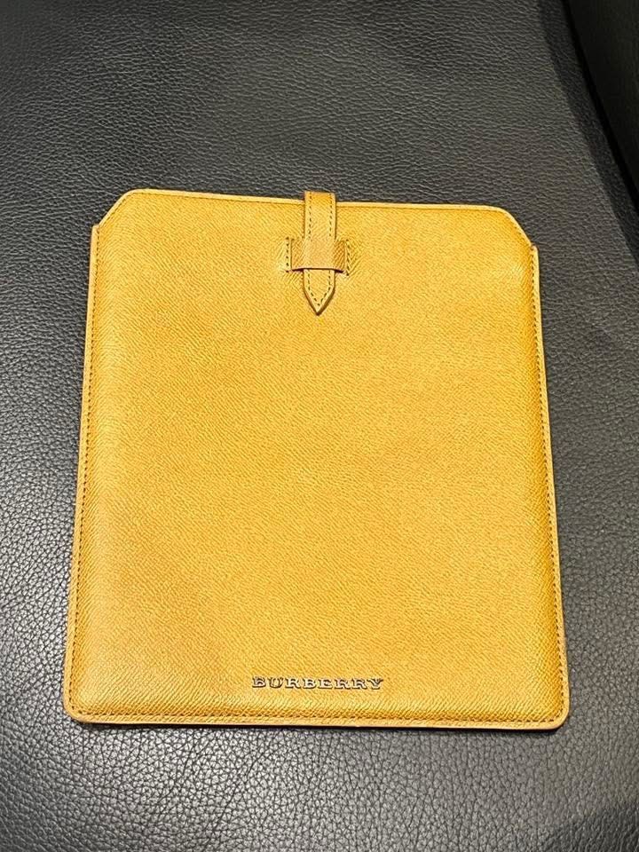 Burberry Tablet Sleeve (Category: Laptop Bags & Sleeves) located in Makati City. Submitted by aiahscloset (Listing ID 1436412981, Image 1). Description: - Genuine Burberry tablet sleeve - Mustard yellow color - Secure tab closure - Burberry logo detail - Crafted from leather - Designed for tablets.