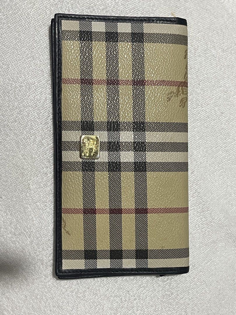 Burberrys Long Wallet (Category: Luxury Bags & Wallets) located in Donsol. Submitted by saksthriftavenuebyluckymaria8 (Listing ID 1436444760, Image 2). Description: - Authentic Burberrys long wallet. - Classic check pattern. - Black leather trim. - Gold-colored emblem with normal signs of usage - Black leather interior. - Multiple card slots. - Embossed Burberrys logo. Made in Italy Black lining has Burberry horse logo 7in x 3 3/4 in .
