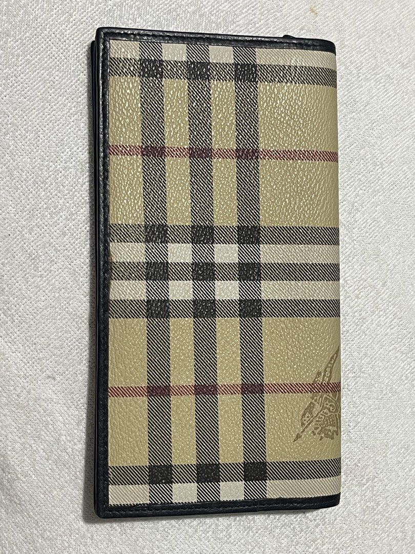 Burberrys Long Wallet (Category: Luxury Bags & Wallets) located in Donsol. Submitted by saksthriftavenuebyluckymaria8 (Listing ID 1436444760, Image 3). Description: - Authentic Burberrys long wallet. - Classic check pattern. - Black leather trim. - Gold-colored emblem with normal signs of usage - Black leather interior. - Multiple card slots. - Embossed Burberrys logo. Made in Italy Black lining has Burberry horse logo 7in x 3 3/4 in .