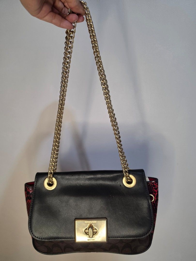 Coach Black Chain Shoulder Bag (Category: Luxury Bags & Wallets) located in General Santos City (Dadiangas). Submitted by love.rossy (Listing ID 1436301890, Image 1). Description: - Black Coach shoulder bag - Gold chain strap - Gold turn-lock closure - Brown Coach monogram pattern on sides - Red snakeskin interior lining - Medium size.