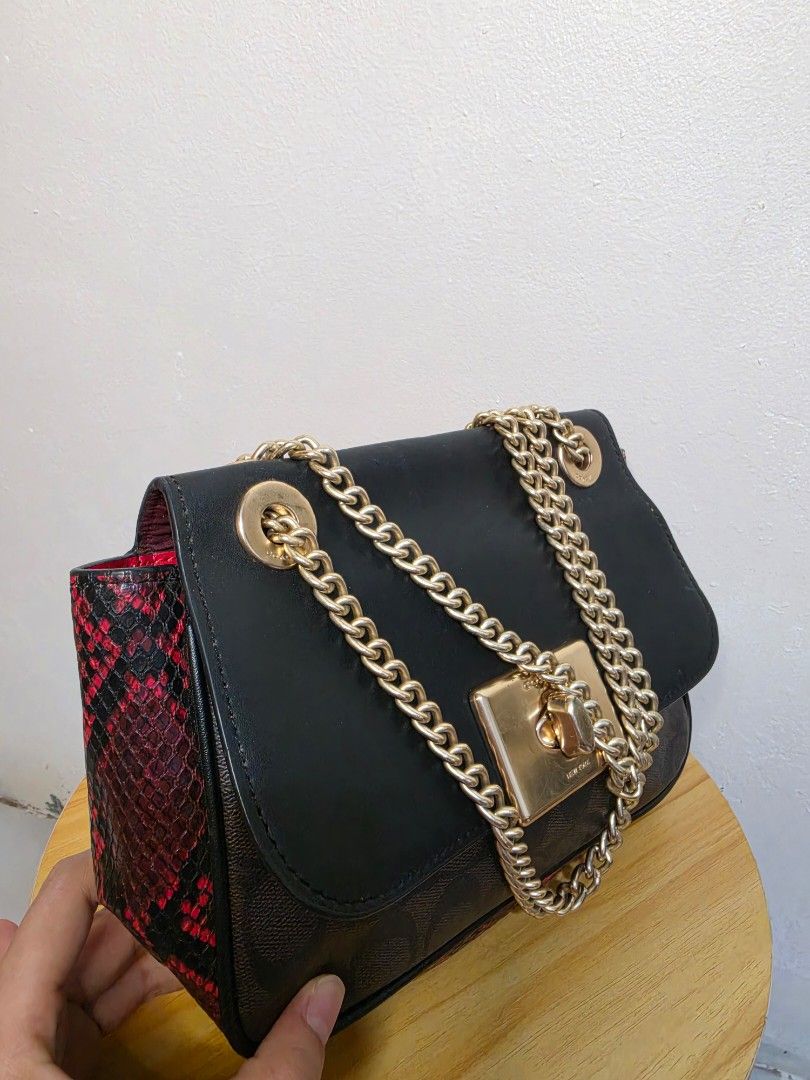 Coach Black Chain Shoulder Bag (Category: Luxury Bags & Wallets) located in General Santos City (Dadiangas). Submitted by love.rossy (Listing ID 1436301890, Image 2). Description: - Black Coach shoulder bag - Gold chain strap - Gold turn-lock closure - Brown Coach monogram pattern on sides - Red snakeskin interior lining - Medium size.