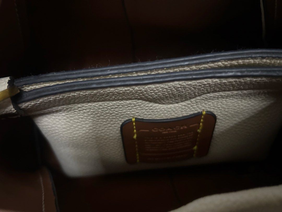 Coach Cream Leather Handbag (Category: Luxury Bags & Wallets) located in Dasmarinas. Submitted by trendyfitsph (Listing ID 1436407775, Image 3). Description: - Cream-colored Coach handbag - Top handle design - Gold-tone 'C' logo - Textured leather exterior - Contrasting interior lining - Interior pocket - Coach label.