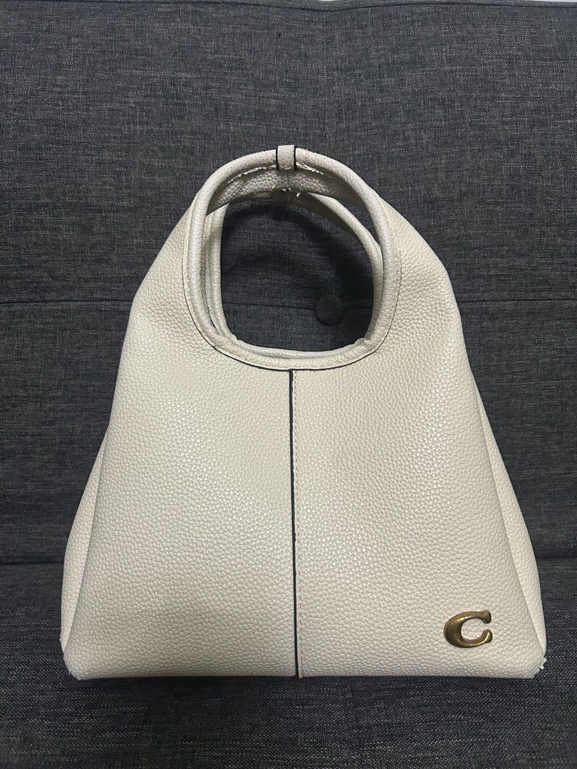 Coach Cream Leather Handbag (Category: Luxury Bags & Wallets) located in Dasmarinas. Submitted by trendyfitsph (Listing ID 1436407775, Image 1). Description: - Cream-colored Coach handbag - Top handle design - Gold-tone 'C' logo - Textured leather exterior - Contrasting interior lining - Interior pocket - Coach label.