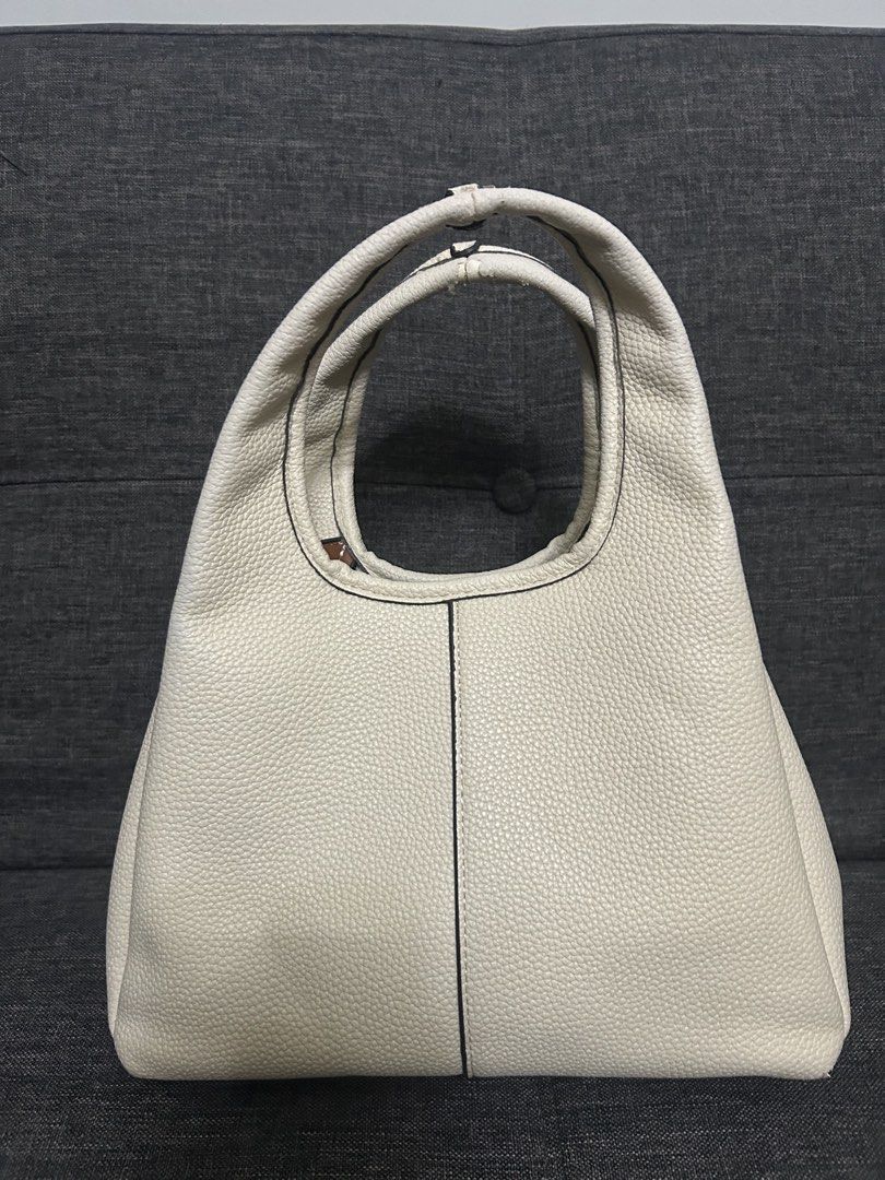 Coach Cream Leather Handbag (Category: Luxury Bags & Wallets) located in Dasmarinas. Submitted by trendyfitsph (Listing ID 1436407775, Image 2). Description: - Cream-colored Coach handbag - Top handle design - Gold-tone 'C' logo - Textured leather exterior - Contrasting interior lining - Interior pocket - Coach label.