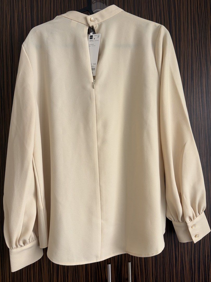GU yellow-cream Long Sleeve Blouse (Category: Blouses) located in Manila. Submitted by na.serr (Listing ID 1436329175, Image 2). Description: - Elegant yellow-cream blouse - Long sleeves - High neckline - Buttoned cuffs - Keyhole back with button closure - Smooth, lightweight fabric - Versatile for formal or casual wear.