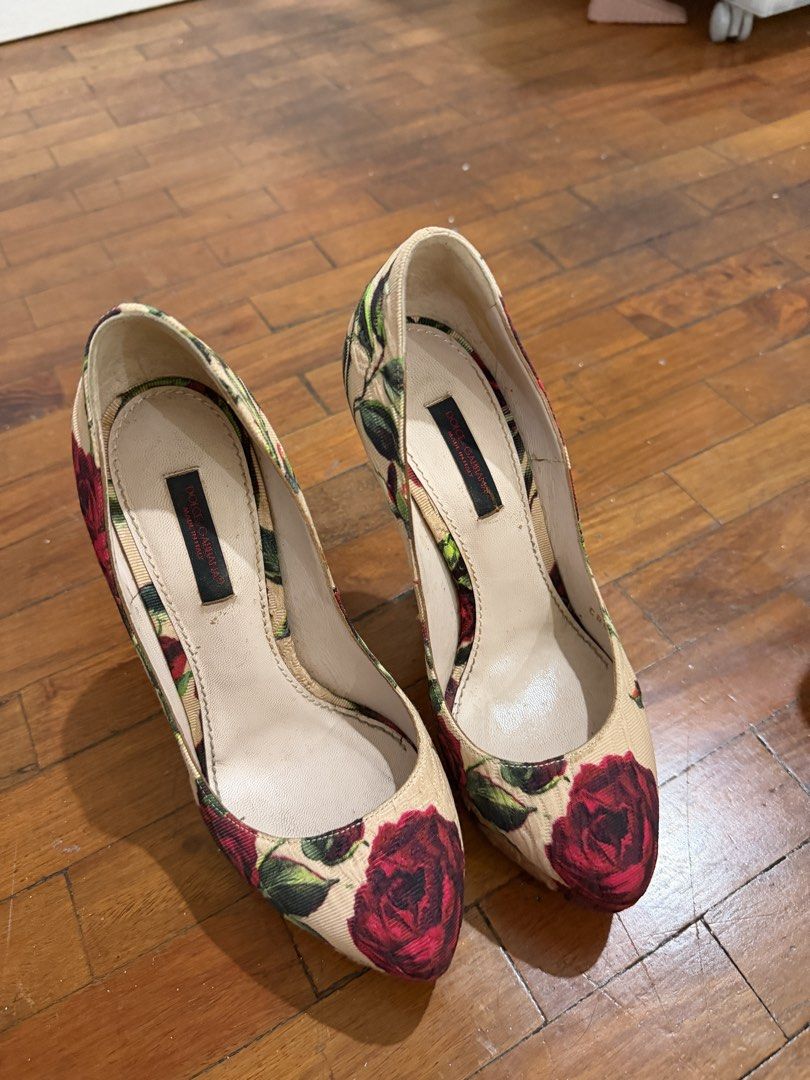 Dolce & Gabbana Floral Print Heels (Category: Heels) located in Makati City. Submitted by prelovedclothes18 (Listing ID 1436343580, Image 1). Description: Elegant Dolce & Gabbana heels featuring a beautiful floral print. These heels have a classic pointed-toe design and a high heel. The interior shows the brand's logo. The exterior features a beige background with red roses and green leaves. Perfect for special occasions or adding a touch of soph