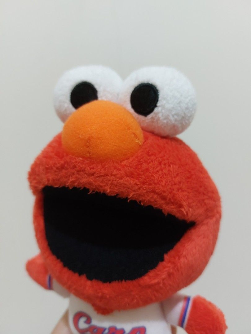 Elmo Carp Plush Toy (Category: Plushies & Soft Toys) located in Mandaluyong City. Submitted by 13thsilverrabbit (Listing ID 1436309213, Image 2). Description: Adorable Elmo plush toy is wearing a Carp baseball uniform. It features Elmo's signature red fur, white eyes, and orange nose. The back of the toy has "ELMO" printed on it. It's a cute and cuddly item for any Elmo or baseball fan..