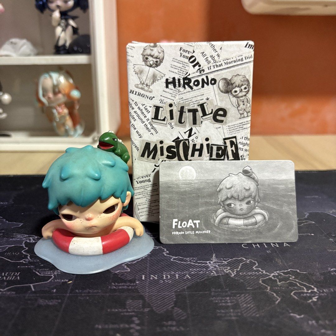 Hirono Little Mischief Float Figure (Category: Designer & Blind Box Toys) located in Mandaluyong City. Submitted by batmanbale (Listing ID 1436286951, Image 1). Description: Hirono Little Mischief figure features the Float design. It includes the figure itself, a small card, and the original box. The figure depicts a character with blue hair and a red and white floatie. A small green turtle is perched on the character's head. The box has a newspa
