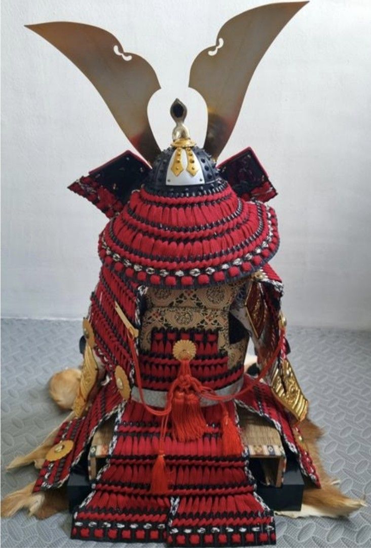 Japanese Samurai Armor (Category: Vintage Collectibles) located in General Trias. Submitted by vcd1707 (Listing ID 1436361954, Image 2). Description: - Authentic Japanese samurai armor - Features a striking red and black design with gold accents - Includes a helmet with decorative elements - Comes with a full set of armor pieces - Displayed on a fur-like base - Perfect for collectors and enthusiasts.