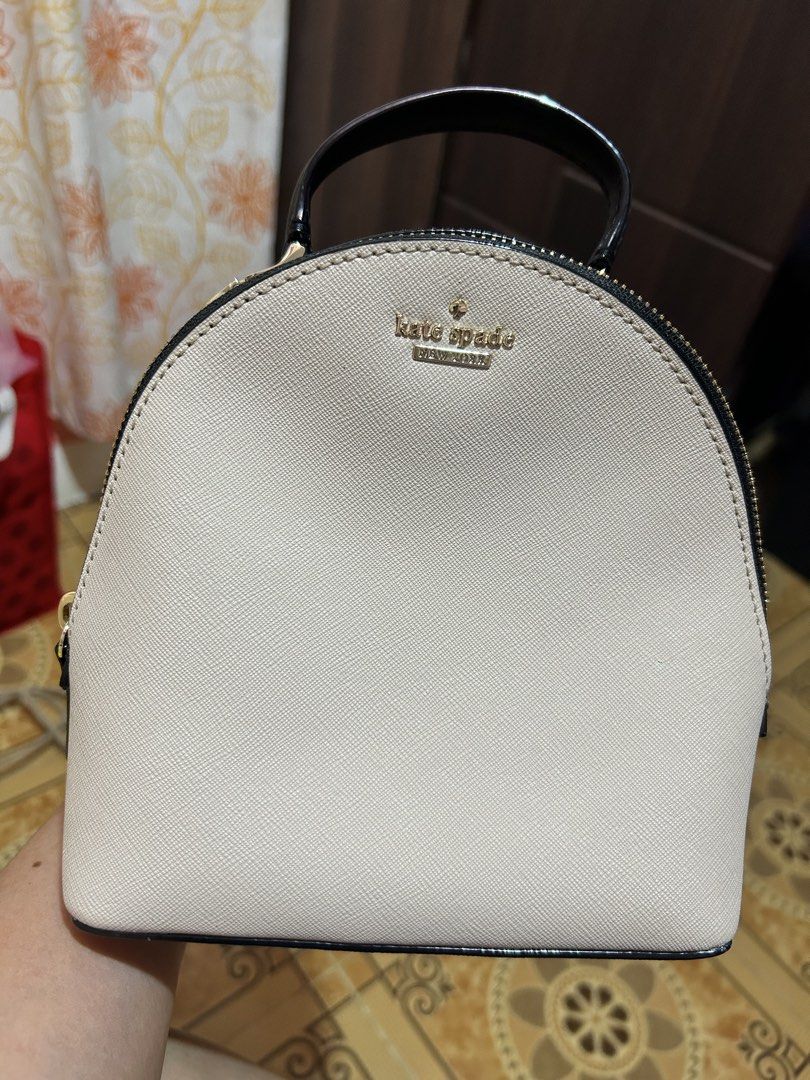 Kate Spade mini backpack (Category: Luxury Bags & Wallets) located in Bagabag. Submitted by jendytaaa (Listing ID 1436404391, Image 1). Description: - Kate Spade dome handbag - Light-colored exterior - Black trim and handle - Features the Kate Spade logo - Zipper closure -with care card.