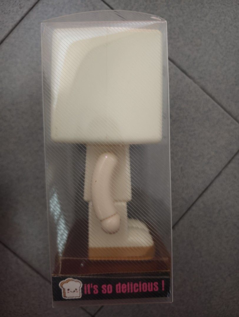 Luck Bread Saving Box (Category: Designer & Blind Box Toys) located in Pantai Remis. Submitted by winkmei (Listing ID 1436340494, Image 3). Description: Luck Bread Saving Box. It features a cute bread-shaped head and a body with arms and legs. The box is in its original packaging. The base of the box has the words "LESS IS MORE" and "It's so delicious!". This is totally new since bought ya.