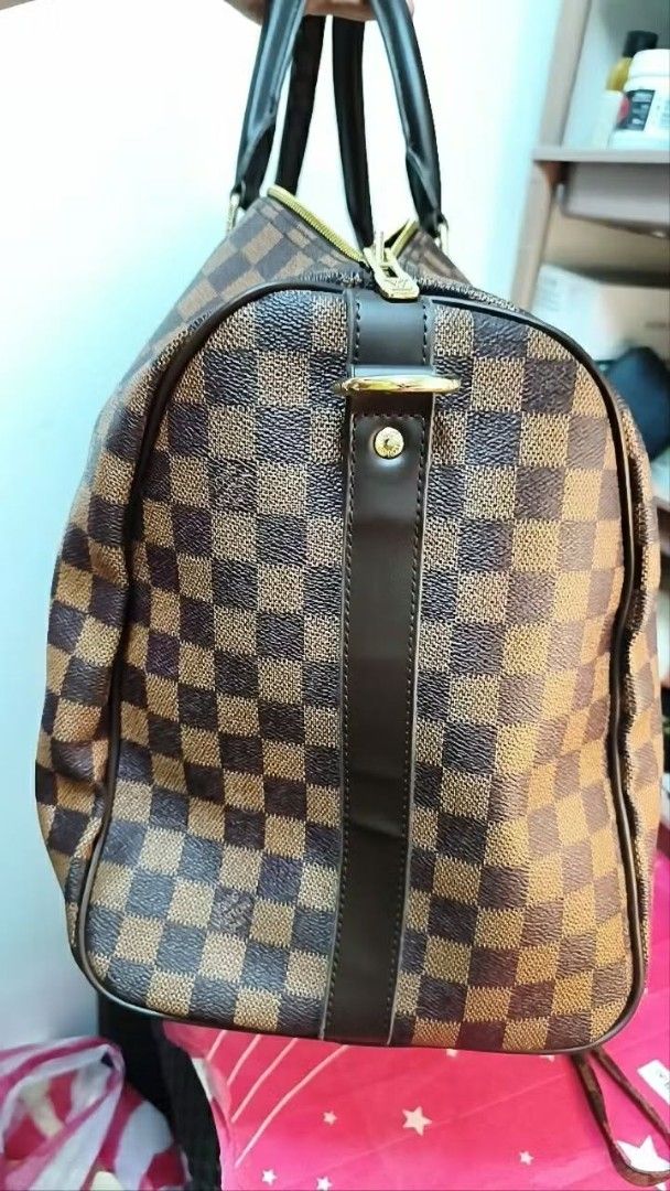 LV Keepal 50 Duffel Bag (Category: Luxury Bags & Wallets) located in Cavite. Submitted by cheleshops (Listing ID 1436378546, Image 3). Description: For Sale!!! LV Keepal 50 Duffel Bag Negotiable Slightly Used Good for travel Japan source No code No dust bag - Keepal 50 check pattern handbag - Includes matching pouch with detachable strap - Red interior lining - Gold-tone hardware - Two top handles - Zipper closure - Spacious design, suitable for 