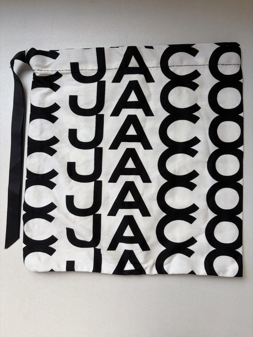 Marc Jacobs Drawstring Bag / dust bag (Category: Luxury Bags & Wallets) located in Manila. Submitted by na.serr (Listing ID 1436329933, Image 1). Description: - Stylish drawstring bag - Bold black and white pattern - Drawstring closure with black ribbon - Repeating brand name design - Versatile for carrying essentials.