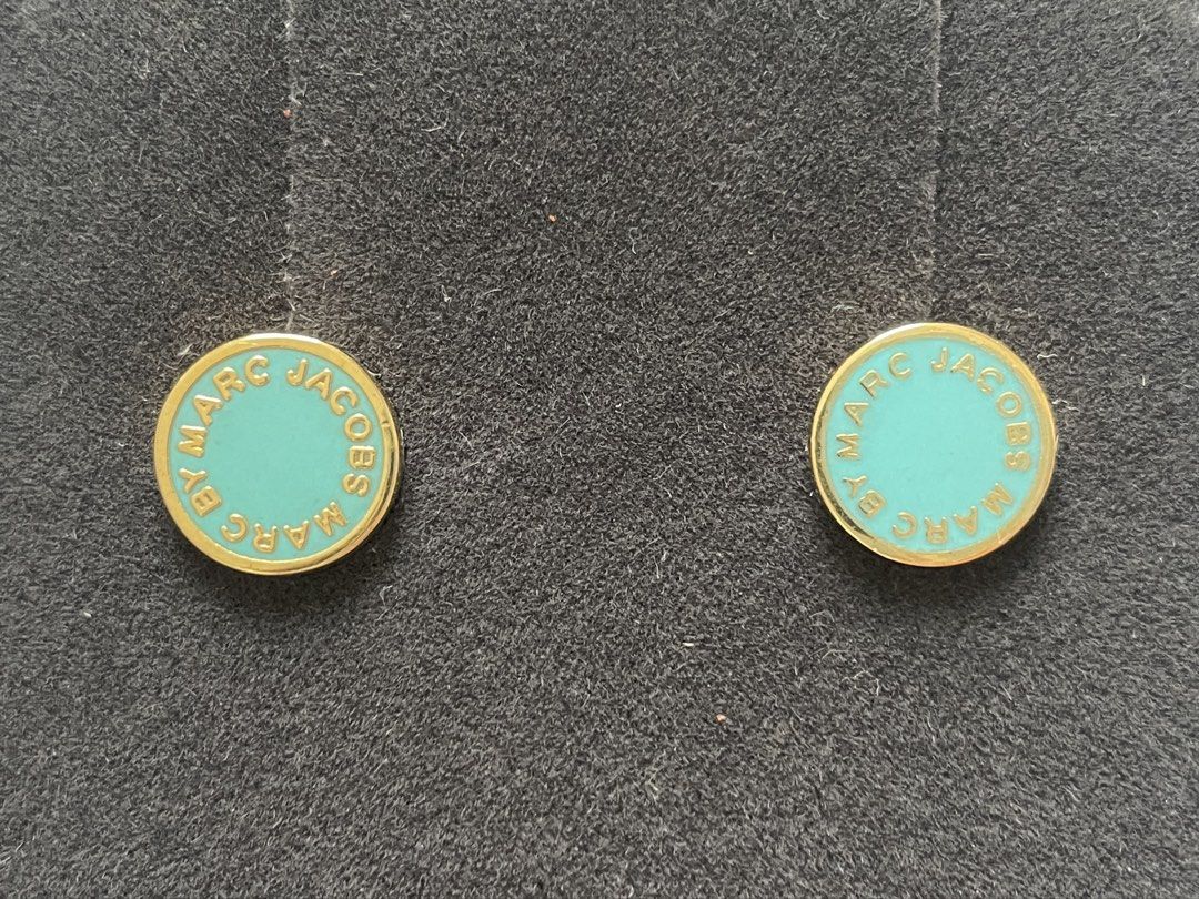 Marc Jacobs Enamel Stud Earrings （分類：耳環）位於 Hong Kong。 由 sab.li 提交（商品編號 1436305901，圖片 2）。簡介： These earrings feature a circular design with a turquoise enamel center and gold-tone trim. The brand name, "Marc Jacobs", is inscribed around the edge. The earrings have a post back closure. They are a stylish accessory for everyday wear.。