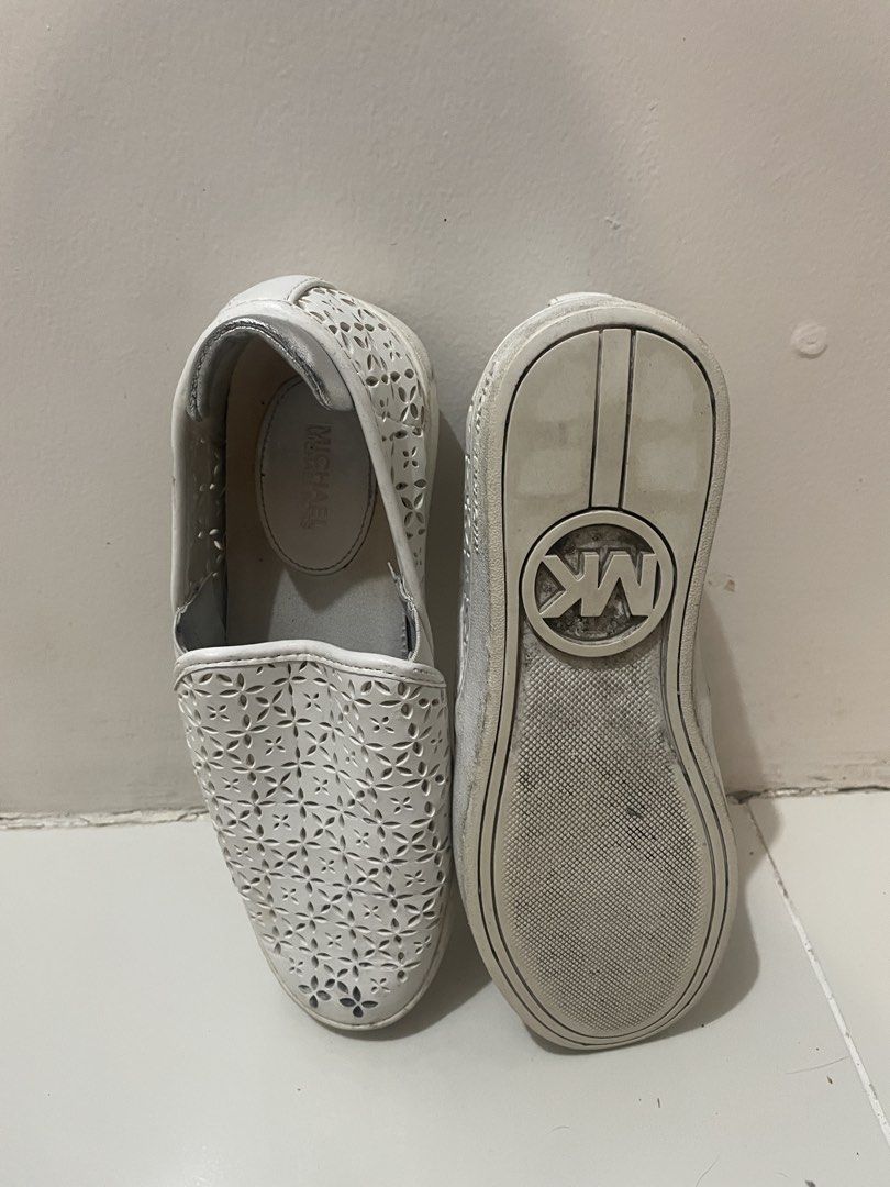 Michael Kors White Slip-on Shoes (Category: Sneakers) located in Manila. Submitted by ohmamarge (Listing ID 1436441809, Image 2). Description: - Michael Kors slip-on shoes - White color - Floral cut-out design - Silver accent on heel - Signs of wear on soles - Can still be cleaned.