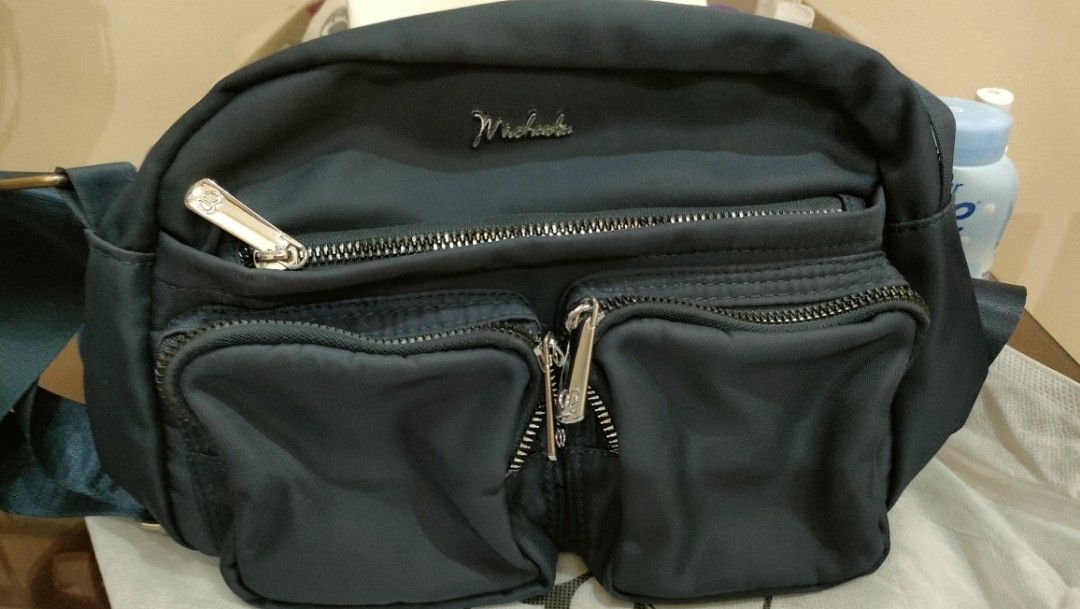MICHAELA BAG (BODY BAG) (Category: Belt bags, Clutches and Pouches) located in Valenzuela. Submitted by suzieabla27500 (Listing ID 1436318108, Image 1). Description: - Stylish waist bag - Multiple zippered compartments - Sleek design with silver zipper - Branded logo - Durable, water-resistant material - Ideal for travel and everyday use - Keeps essentials organized and hands-free used na yan pero maayos oa nman at magagamit,madami zipper or mala